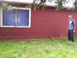 Side view of the bunck house - Jay is standing  next to the kitchen door  where we'll set up 12 propane grills  behind a safety corral for our cooking needs the first summer. A 30x60 grassy area with tree coverage right infront of Jay wiill be our outdoor dining room for all meals - We will have party canopies  set up incase of summer rain.